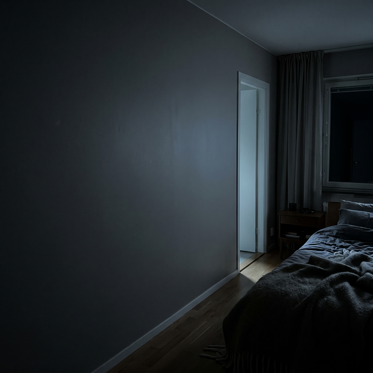 Bar og mørk vegg ved sengen, uten lampe og uten stikkontakt